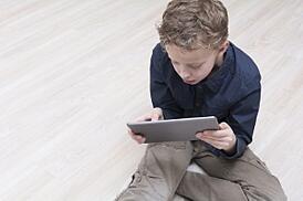 Boy_playing_social_game_on_tablet, featured on www.blog.marketresearch.com