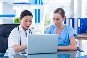 Clinicians looking at a computer with clinical trial software