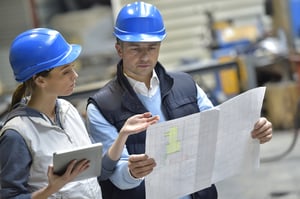 Engineers in mechanical factory reading instructions-1