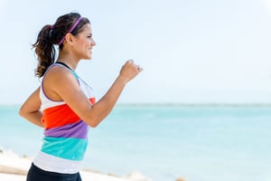 Fit girl running outdoors by the beach