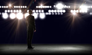 Rear view of businessman standing in lights of stage