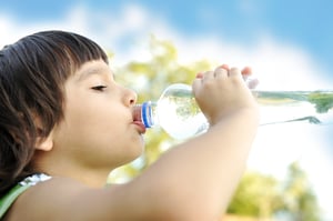 Child drinking pure water in nature