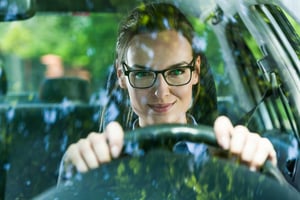 Young attractive woman in glasses driving a car