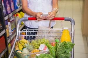 woman buy products and texting at supermarket